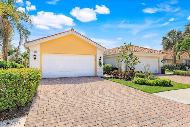 4221 Saint George Ln, Naples, FL 34119 - single story home with stucco siding, driveway, a tile roof, and an attached garage