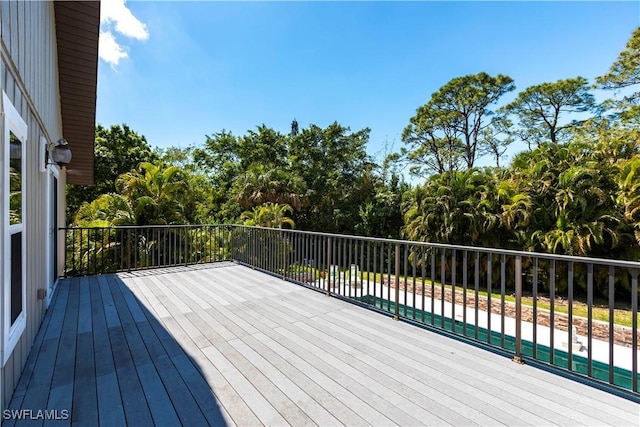 183 Old Tamiami Trl, Naples, FL 34110 - wooden deck featuring fence and view of scattered trees