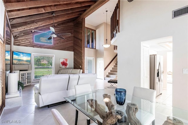183 Old Tamiami Trl, Naples, FL 34110 - living area featuring high vaulted ceiling, tile patterned floors, a ceiling fan, stairs, and beamed ceiling