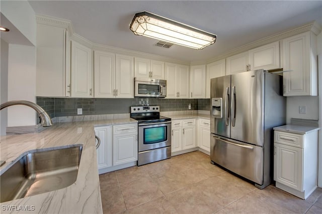 17225 Castleview Dr, North Fort Myers, FL 33917 - kitchen with light stone counters, decorative backsplash, a sink, and stainless steel appliances