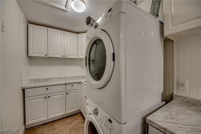 17225 Castleview Dr, North Fort Myers, FL 33917 - laundry room featuring stacked washer and clothes dryer, cabinet space, and light tile patterned floors