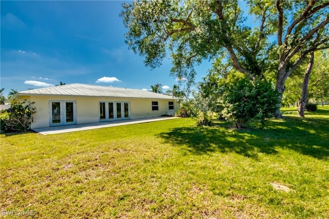 17225 Castleview Dr, North Fort Myers, FL 33917 - back of house featuring french doors, stucco siding, a yard, and a patio area