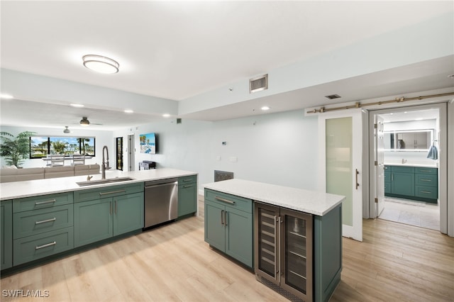 kitchen featuring light wood finished floors, visible vents, green cabinets, dishwasher, and a sink