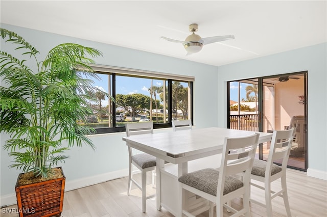 dining room with light wood-style flooring, baseboards, and a ceiling fan