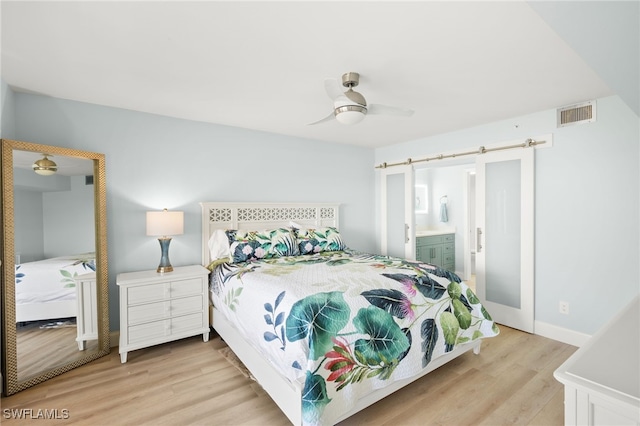 bedroom featuring visible vents, ensuite bath, light wood finished floors, baseboards, and ceiling fan