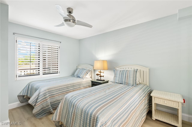 bedroom featuring a ceiling fan, baseboards, and wood finished floors