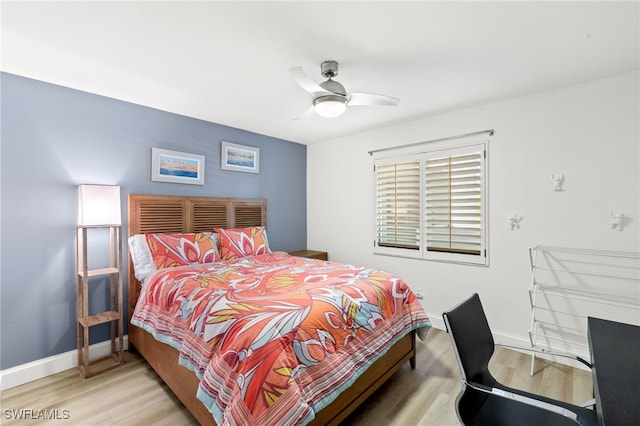 bedroom with a ceiling fan, wood finished floors, and baseboards