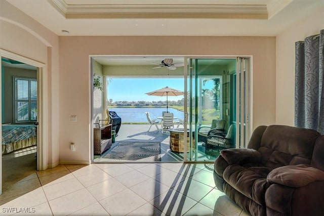 interior space with a raised ceiling, a healthy amount of sunlight, and a water view