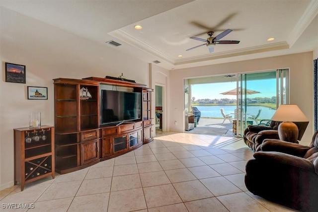 living room featuring ceiling fan, visible vents, a raised ceiling, and light tile patterned flooring