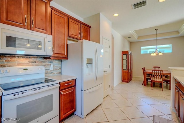 kitchen with visible vents, tasteful backsplash, white appliances, an inviting chandelier, and a raised ceiling