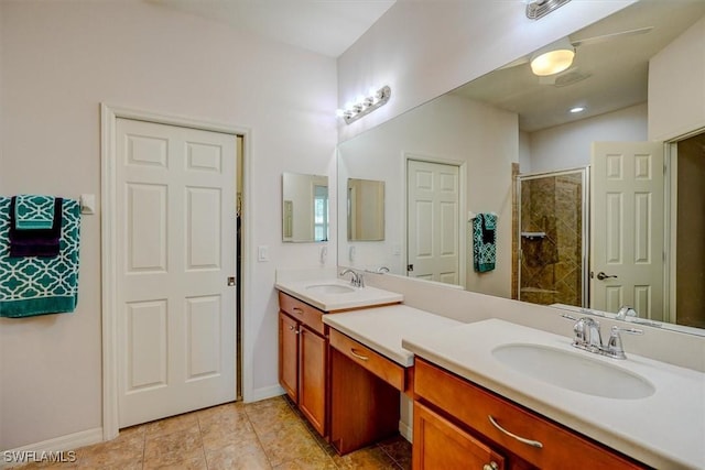 full bath featuring double vanity, a stall shower, baseboards, and a sink