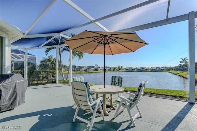 view of patio / terrace featuring glass enclosure, a grill, and a water view