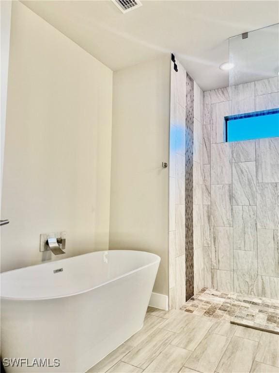 full bath featuring a shower stall and a freestanding bath