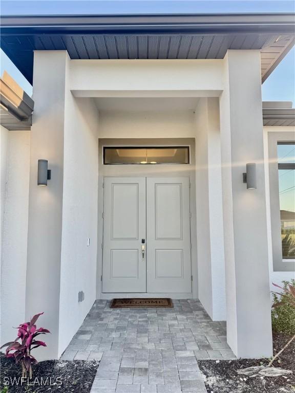 entrance to property with stucco siding