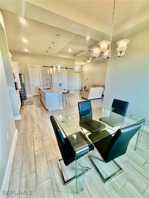 dining space with visible vents, baseboards, an inviting chandelier, and wood tiled floor