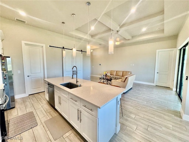 kitchen with dishwashing machine, visible vents, wood finish floors, a sink, and a barn door