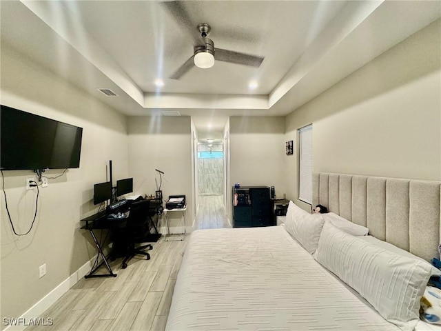 bedroom with wood finish floors, visible vents, a raised ceiling, recessed lighting, and baseboards