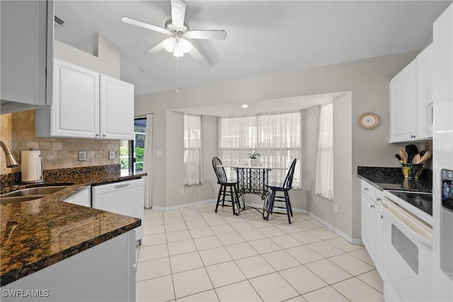 kitchen with tasteful backsplash, dishwasher, stove, white cabinets, and a sink