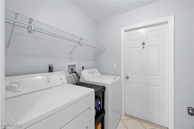 clothes washing area featuring laundry area, light tile patterned flooring, and independent washer and dryer