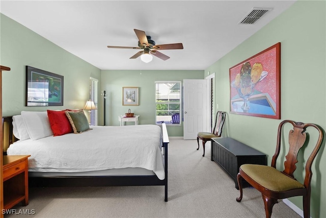 bedroom featuring visible vents, light colored carpet, and a ceiling fan