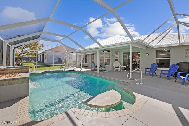 pool with glass enclosure, a patio, and a ceiling fan