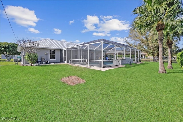 back of property featuring a lanai, a yard, and fence