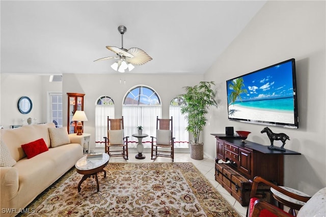 living area with light tile patterned flooring, ceiling fan, and vaulted ceiling