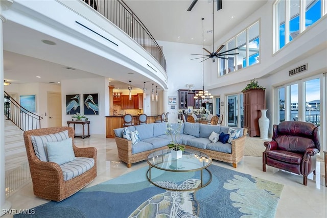 living area featuring recessed lighting, stairway, a high ceiling, and ceiling fan with notable chandelier