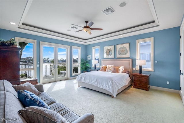 bedroom featuring visible vents, baseboards, carpet flooring, a raised ceiling, and access to outside