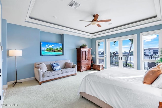 bedroom featuring access to exterior, visible vents, baseboards, carpet floors, and a raised ceiling