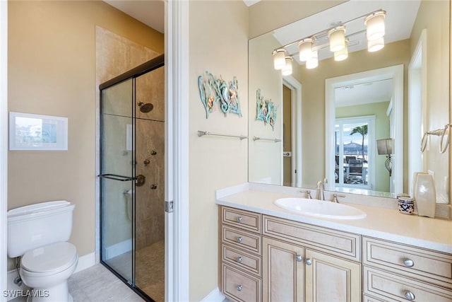 full bath with baseboards, vanity, toilet, and a shower stall