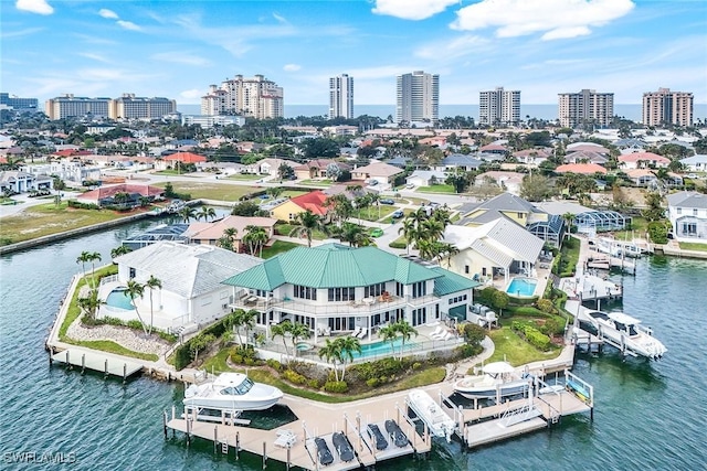 birds eye view of property with a city view and a water view