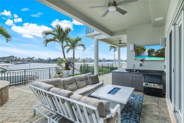 view of patio featuring fence, area for grilling, ceiling fan, an outdoor living space with a fire pit, and a sink