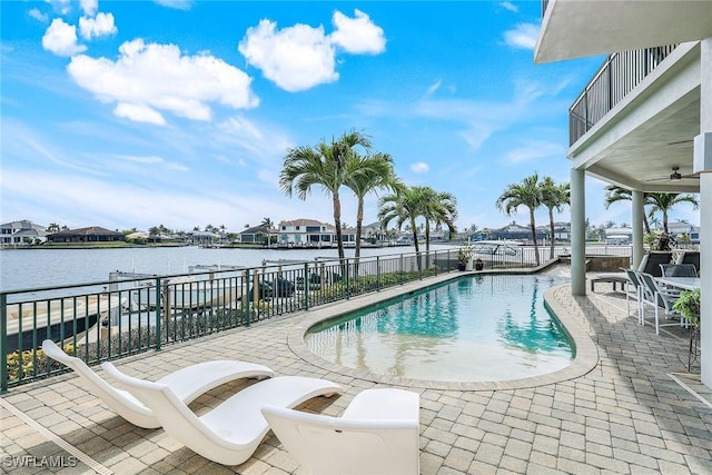 view of pool with a patio, a fenced in pool, and a water view