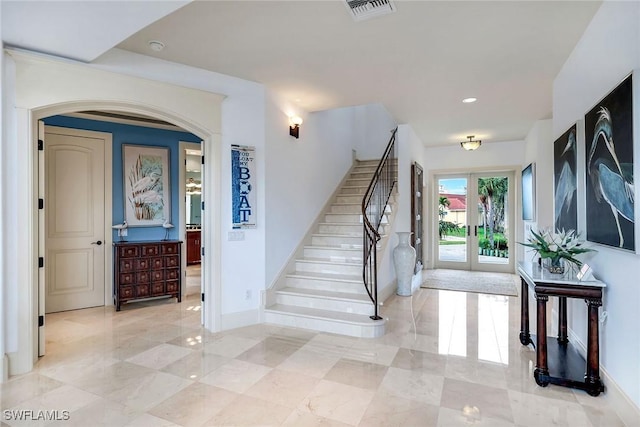 foyer entrance featuring stairway, french doors, baseboards, and visible vents