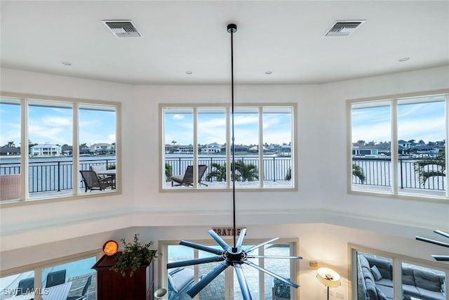 details with recessed lighting, visible vents, and a water view