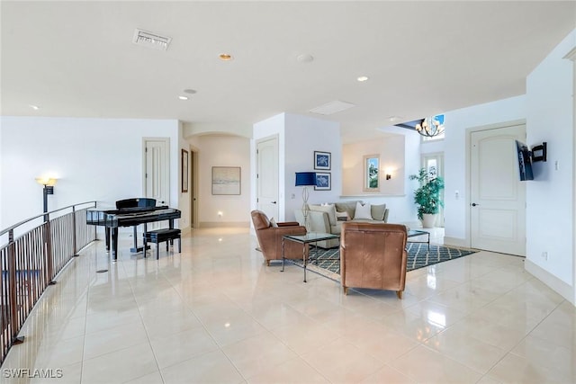 living room with visible vents, baseboards, light tile patterned floors, recessed lighting, and arched walkways