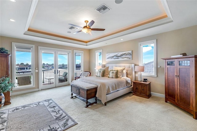 bedroom with visible vents, a tray ceiling, multiple windows, french doors, and access to outside