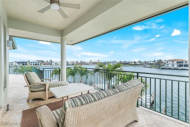 balcony featuring a water view and ceiling fan