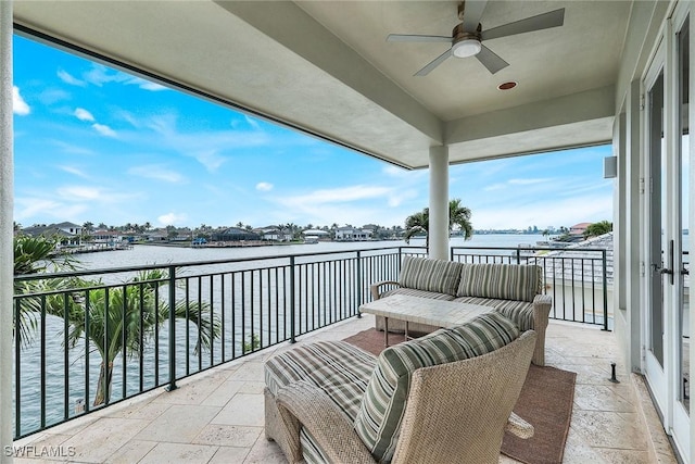 balcony featuring a water view and a ceiling fan