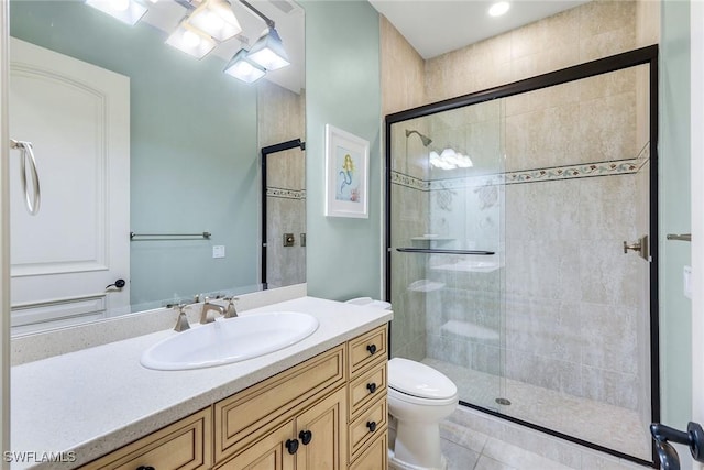 full bathroom featuring tile patterned floors, vanity, toilet, and a shower stall