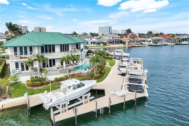 dock area featuring a patio area, boat lift, a pool with connected hot tub, and a water view