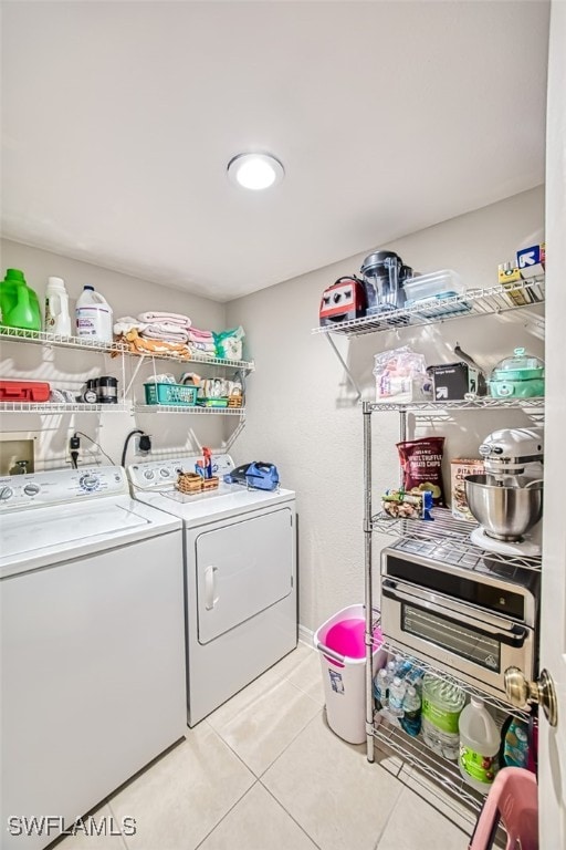 laundry area with light tile patterned floors, laundry area, and washer and clothes dryer