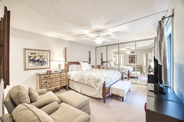 carpeted bedroom featuring a textured ceiling and a ceiling fan