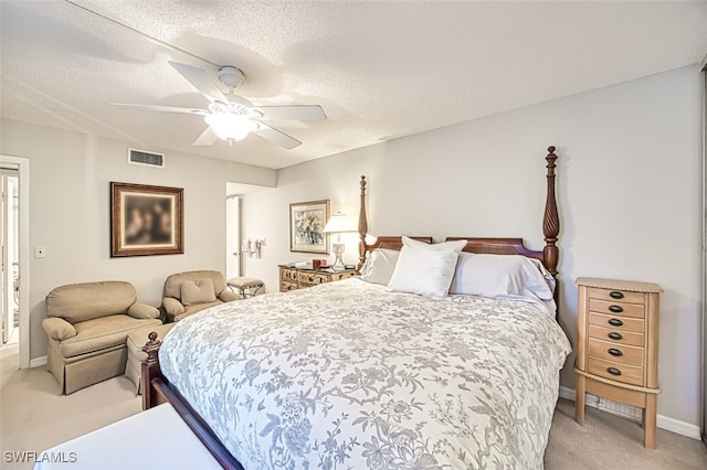 bedroom featuring visible vents, light carpet, a ceiling fan, a textured ceiling, and baseboards