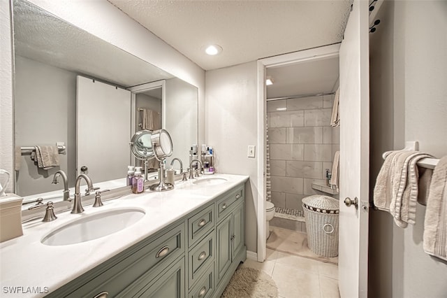 bathroom with tile patterned floors, double vanity, toilet, and a sink