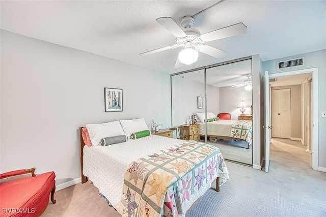 bedroom featuring visible vents, light carpet, a closet, baseboards, and ceiling fan