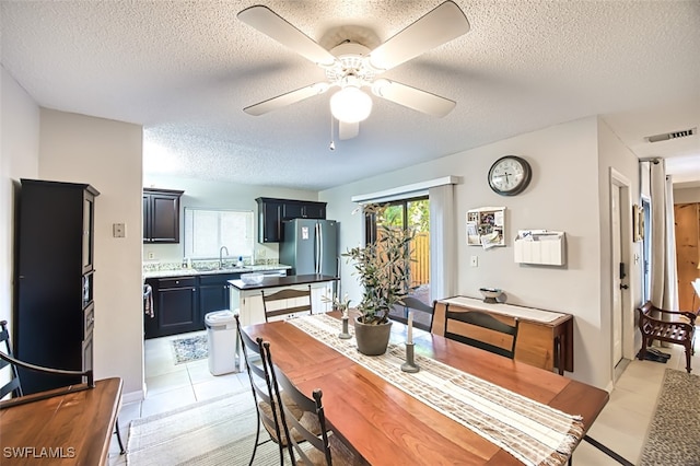 dining area with plenty of natural light, a textured ceiling, and ceiling fan