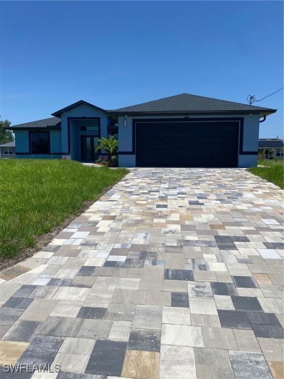 4108 35th St SW, Lehigh Acres, FL 33976 - view of front of house featuring an attached garage, decorative driveway, a front yard, roof with shingles, and stucco siding