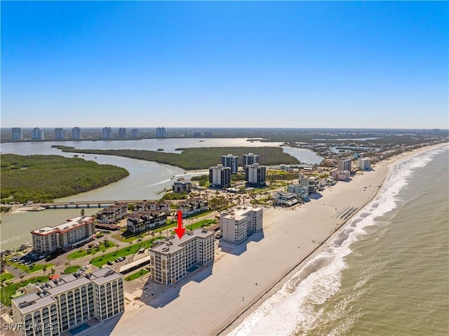 drone / aerial view featuring a city view, a view of the beach, and a water view